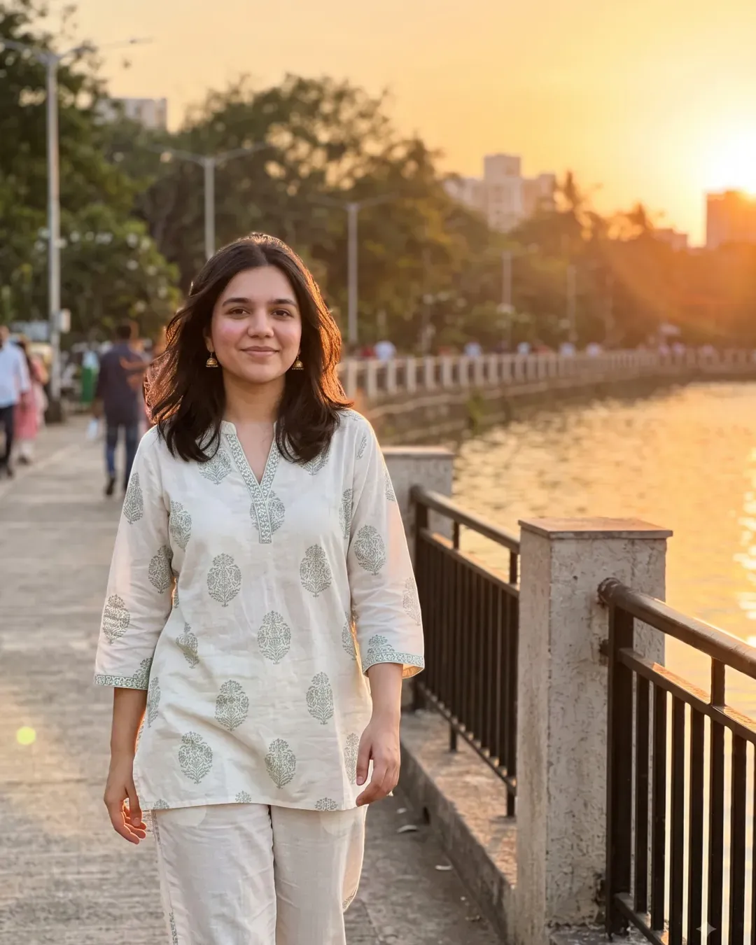 AI-generated image of Rutu in a white printed cotton co-ord set by a lake at sunset